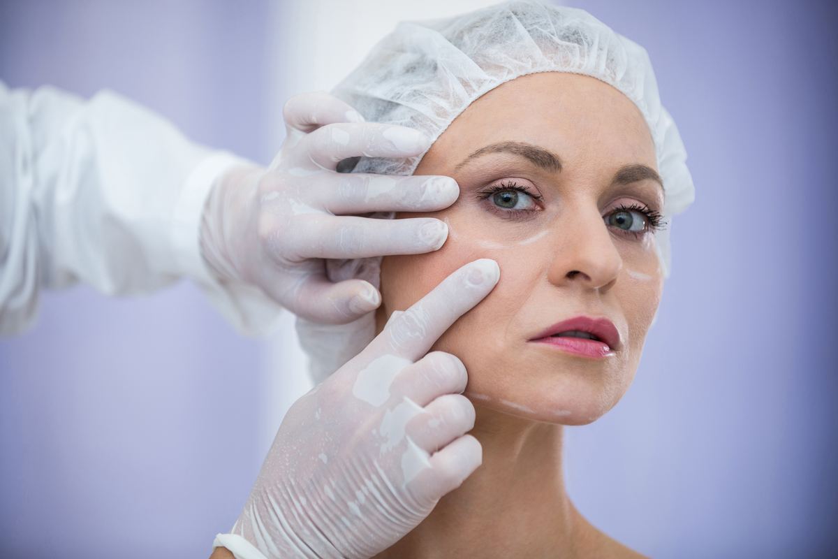 Examen du visage d'une patiente par le chirurgien